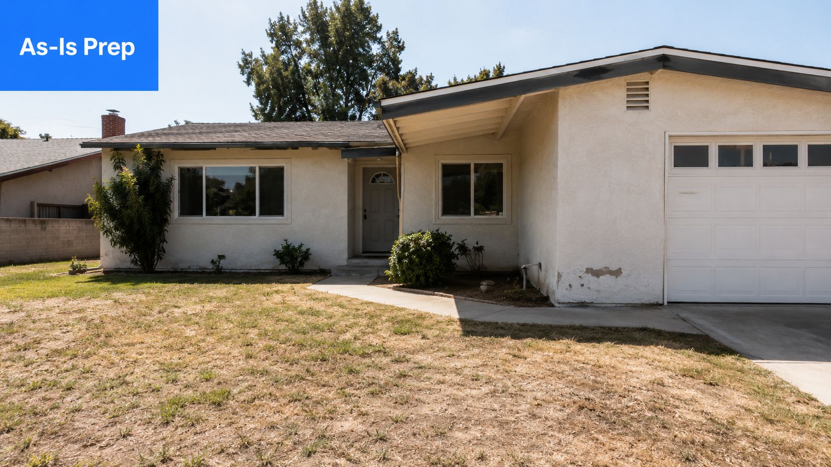 A single-story suburban home with a stucco exterior, a garage, and a dry, brown grass lawn.